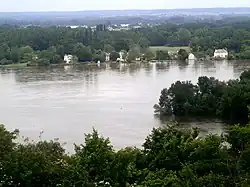 Photographie en couleurs représentant deux cours d'eau en crue se rejoignant.