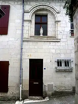 photographie en couleurs d'une façade percée d'une baie en plein cintre.