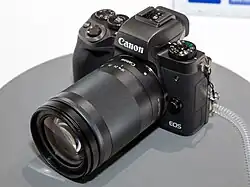 Description de l'image Canon EOS M5 front-left 2017 CP+.jpg.