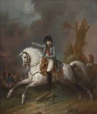 Napoléon en redingote sur un cheval au galop sur un champ de bataille