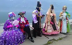 Photographie en couleurs montrant des individus déguisés ; lac en arrière-plan.