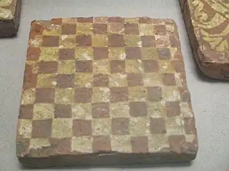 Carreau de pavage figurant un damier.