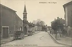 Carte postale représentant la rue de l'Eglise à Nomexy entre 1880 et 1945.