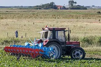 Bineuse de précision Monosem sur tracteur à roues étroites, utilisable pour casser une croûte de battance entre les rangs de semis ou plantation.