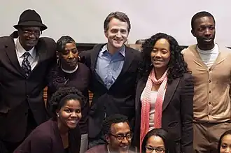 Photo de groupe d'une dizaine de personnes devant un tableau d'université.