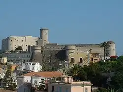 Photo d'un imposant château-fort entouré de maisons d'habitation.
