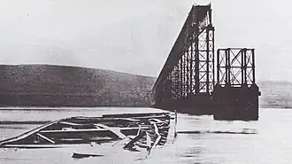 Les vestiges du pont et des poutres tombées dans le fleuve.