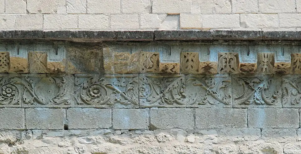 Frise de rinceaux et corniche à faux modillons de la façade du collatéral sud.