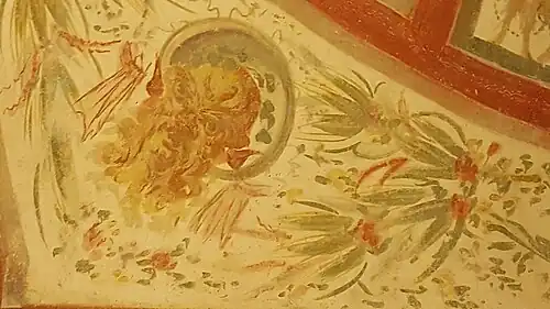 Masque de Silène parmi des branches d'olivier.