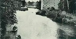 Ancienne carte postale datant du début du dix-neuvième et représentant une rivière qui traverse une commune de France.