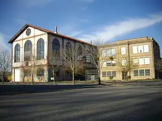 photo couleur d'un bâtiment à structure métallique et murs ouverts de grandes verrières.