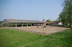 Terrain vu de loin avec des cavaliers à cheval.