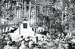 Vieille photographie en noir et blanc d'une cérémonie d'hommage devant un monument funéraire japonais