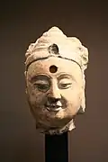 Tête de Pratyeka Buddha (Bizhijiafo). Grès, H. : 33&nbsp;cm. Fin du VIe&nbsp;siècle. Musée Cernuschi. Site du musée.