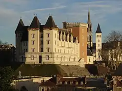 Photographie en couleurs d'un château au milieu d'une ville.