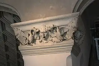 Photographie en couleurs d'un élément sculpté d'un escalier ancien.