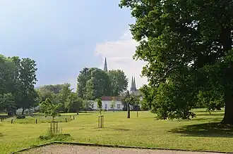 Le parc du château Pirmez avec les flèches de l'église Saints-Pierre-et-Paul.