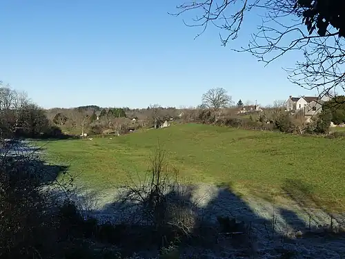 Pré au nord-ouest de la route départementale 997, en bordure du bourg.