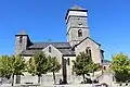 Vue latérale de l'église dominée par son imposant clocher-tour qui s'élève à la verticale de la croisée du transept