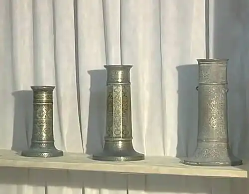 Des chandeliers à décor épigraphique et floral gravé et incrusté d'Iran