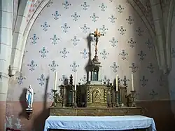 Autel en bois polychrome avec un petit retable tabernacle à cinq niches, à sa gauche une statue de Notre-Dame de Lourdes