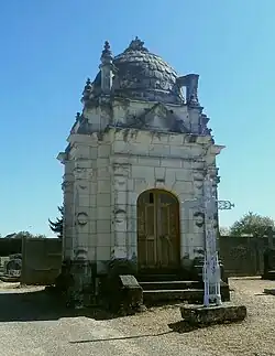 Photographie en couleurs d'une chapelle en pierre surmontée d'un dôme à écailles.