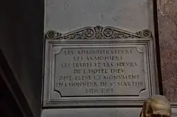 Plaque portant l'inscription : LES ADMINISTRATEURS LES AUMONIERS LES FRERES ET LES SŒURS DE L'HOTEL DIEU ONT ELEVE CE MONUMENT EN L'HONNEUR DE STE MARTHE MDCCCL