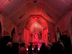 Une chapelle illuminée d'un éclairage de scène aux teintes rouges.