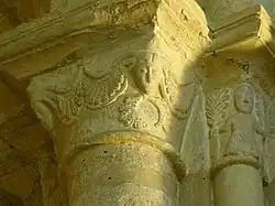 chapiteau décoré de figures humaines et de fougères