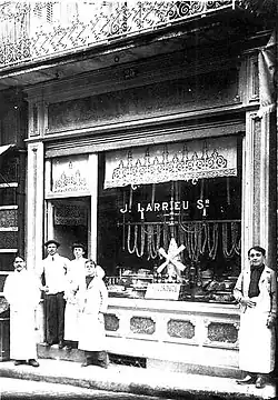 Jean Larrieu et sa famille posant devant sa charcuterie située 25 rue Léon-Gambetta.