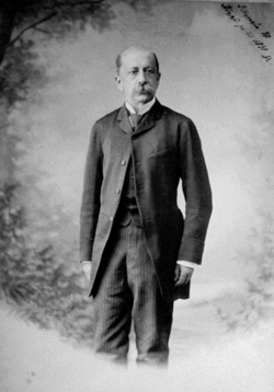 photographie noir et blanc d'un homme moustache debout