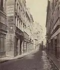 Charles Marville : Rue des Bourdonnais à hauteur du no&nbsp;31 (premier plan, gauche) prise en direction de la rue Saint-Honoré en 1865.