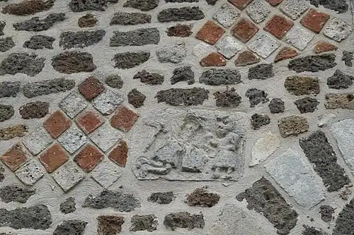 Bas-relief à gauche de l'arc de déchargede la porte d'entrée de l'église.