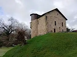 Façade sud et tour d'angle avec partie supérieure en bois. On aperçoit une partie des douves restantes.