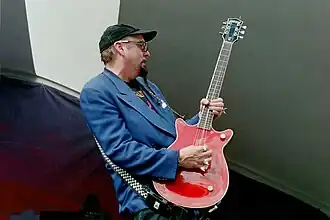 photo d'un homme jouant d'une guitare rouge.