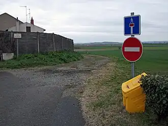 Un chemin de terre avec un panneau indiquant une impasse et un sens interdit