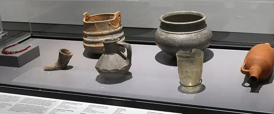 Culture de Tcherniakhov, Ukraine, sur la mer Noire. 300-350 de notre ère: de gauche à droite : perles de corail, godet en forme de botte, vase en forme de seau, vase, cruche, gobelet en verre. Amphore vinaigre romaine (fin IVe&nbsp;siècle).