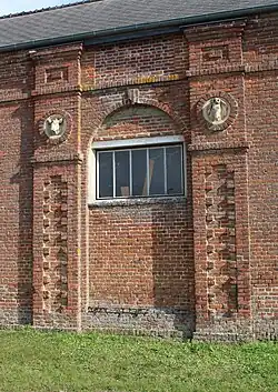 Mur de ferme orné de deux têtes d'animaux.