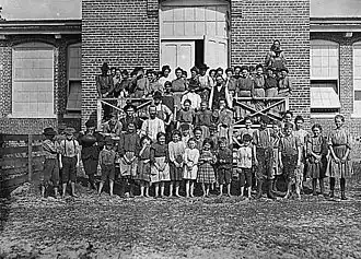 Photographie d'un groupe d'enfants devant leur usine