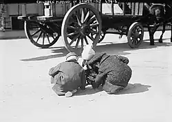 Photographie en noir et blanc d'enfants jouant dans la rue à New York.