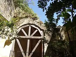 Photographie en couleurs d'une niche en plein cintre étayée par une armature en bois.