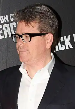 Christopher McQuarrie portant des lunettes, une chemise et une veste.
