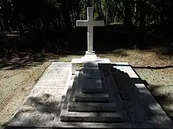 Croix latine entourée de deux pierres tombales.