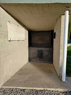 Vue de l'intérieur de la maison du visiteur du cimetière dans laquelle se situe une petite armoire encastrée où se situe le registre des sépultures