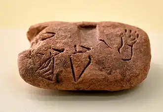 Tablette de comptabilité d'Uruk de la fin du IVe&nbsp;millénaire&nbsp;av. J.-C., portant des signes pictographiques, dont le vase (DUG) au milieu. Pergamon Museum.