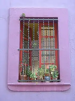Fenêtre avec grille dans la rue menant au Parc Güell à Barcelone.