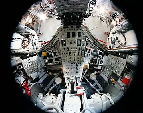 Vue du cockpit prises avec un objectif fisheye montre l’exiguïté de l'espace disponible. Les deux écoutilles sont ouvertes.