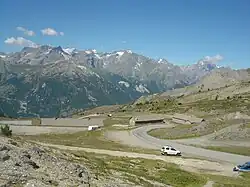 En arrière, les baraquements militaires dans les derniers hectomètres de l’ascension et la vue sur le massif des Écrins.