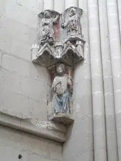 Photographie en couleurs d'un groupe de sculptures murales polychromes dans une église.