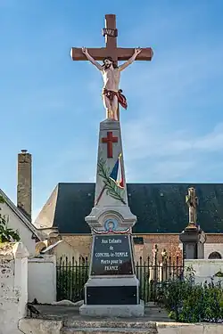 Le monument aux morts devant un calvaire.